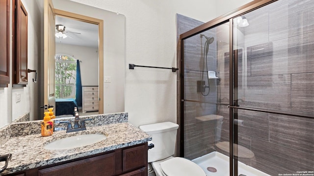 bathroom featuring toilet, a stall shower, and vanity