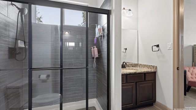 bathroom with a shower stall and vanity