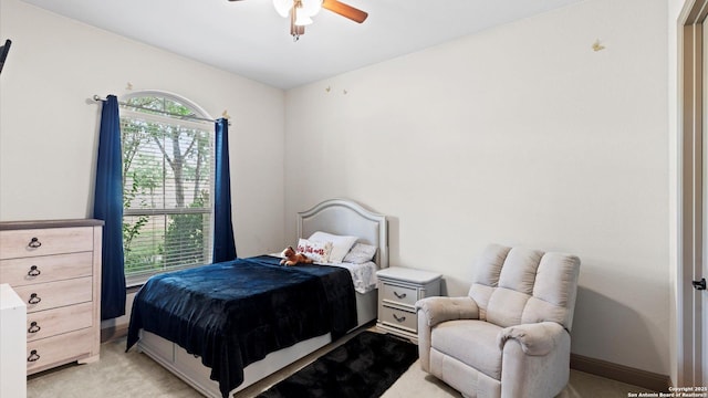 bedroom featuring baseboards, a ceiling fan, and light colored carpet