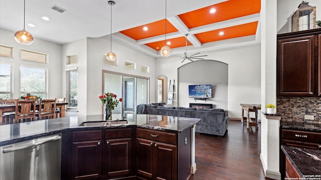 kitchen featuring arched walkways, coffered ceiling, a sink, stainless steel dishwasher, and dark wood finished floors