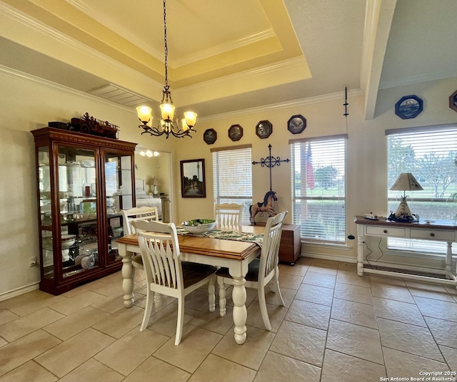 dining area with baseboards, a tray ceiling, a chandelier, and ornamental molding