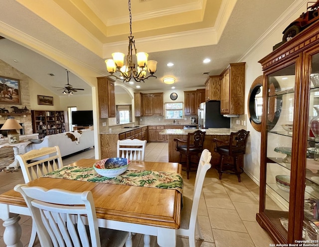 dining area featuring arched walkways, crown molding, a tray ceiling, and ceiling fan with notable chandelier