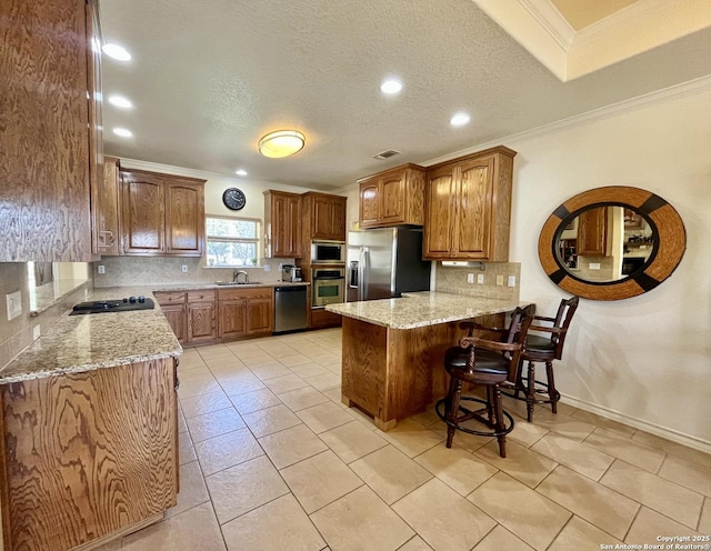 kitchen with tasteful backsplash, brown cabinetry, appliances with stainless steel finishes, a peninsula, and crown molding