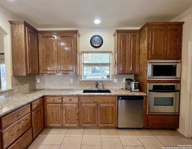 kitchen featuring appliances with stainless steel finishes, crown molding, a sink, and backsplash