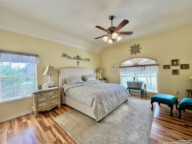 bedroom with lofted ceiling, a ceiling fan, and light wood-style floors