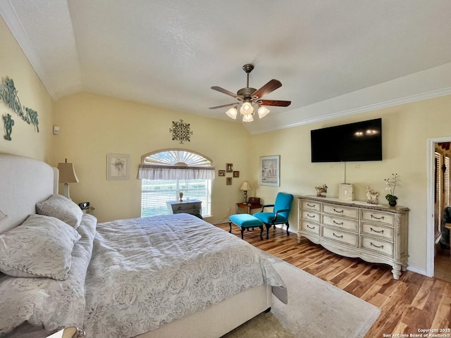 bedroom featuring lofted ceiling, ceiling fan, baseboards, and light wood-style floors