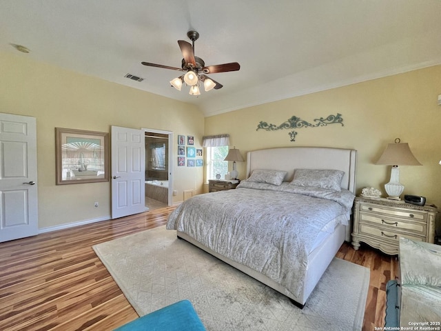 bedroom featuring visible vents, ceiling fan, vaulted ceiling, wood finished floors, and baseboards