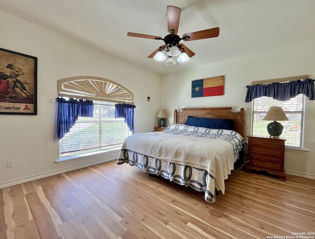 bedroom featuring ceiling fan, light wood finished floors, and baseboards