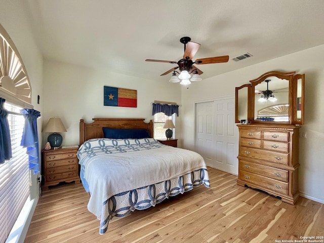 bedroom with a closet, visible vents, light wood-style flooring, and multiple windows