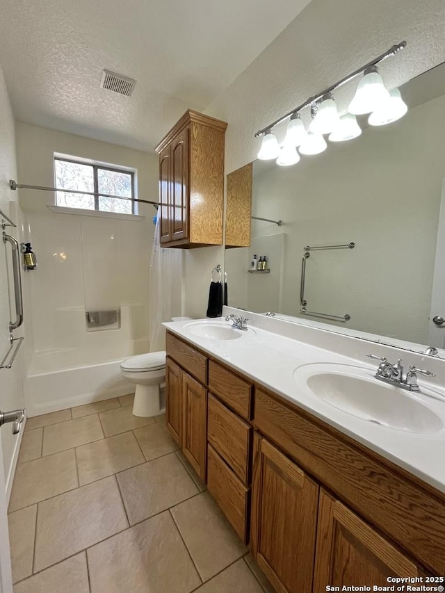 bathroom featuring a textured ceiling, toilet, a sink, and visible vents