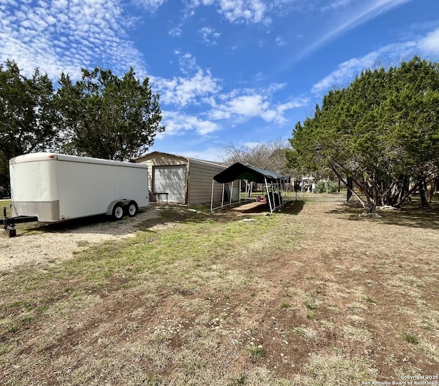 view of yard with driveway, a detached garage, and an outdoor structure