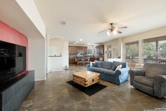 living area with ceiling fan, recessed lighting, visible vents, and baseboards