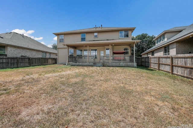 rear view of property featuring a fenced backyard and a yard