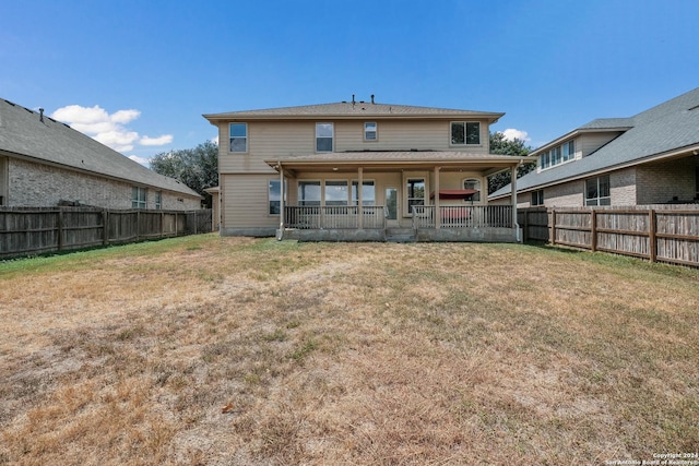 back of property with a fenced backyard and a yard