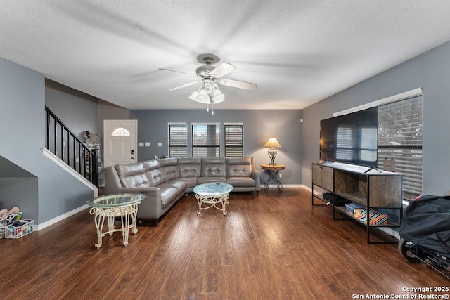 living room featuring stairs, wood finished floors, a ceiling fan, and baseboards