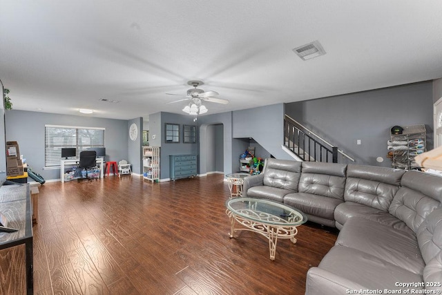 living area with baseboards, visible vents, ceiling fan, stairway, and wood finished floors