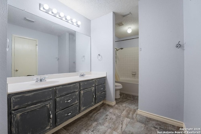 bathroom featuring double vanity, toilet, tub / shower combination, a sink, and a textured ceiling