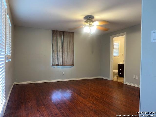 spare room featuring wood finished floors, a wealth of natural light, and baseboards