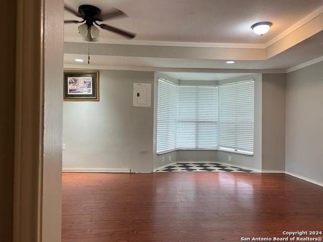 spare room featuring ceiling fan, a raised ceiling, crown molding, and wood finished floors