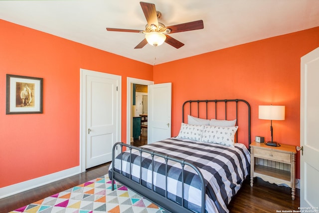 bedroom featuring dark wood-style floors, a ceiling fan, and baseboards