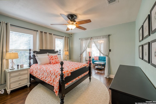 bedroom with baseboards, ceiling fan, visible vents, and dark wood-type flooring