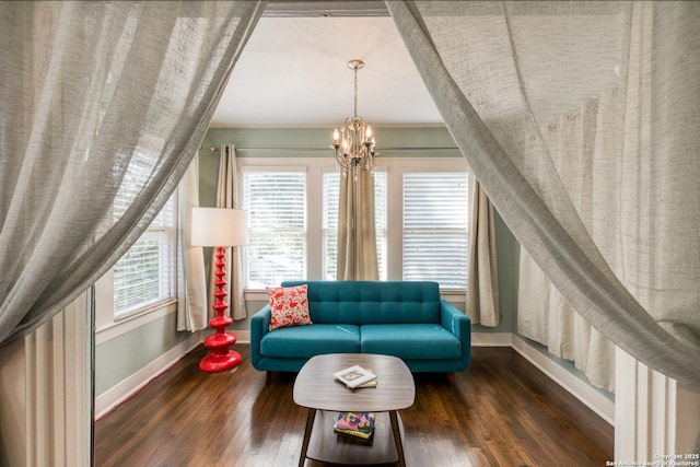 living area featuring a chandelier, wood finished floors, and baseboards