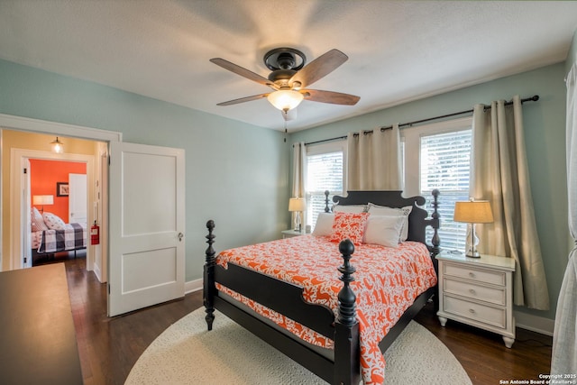 bedroom featuring ceiling fan, baseboards, and dark wood finished floors