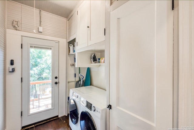 laundry area featuring dark wood-style flooring, washing machine and dryer, and cabinet space