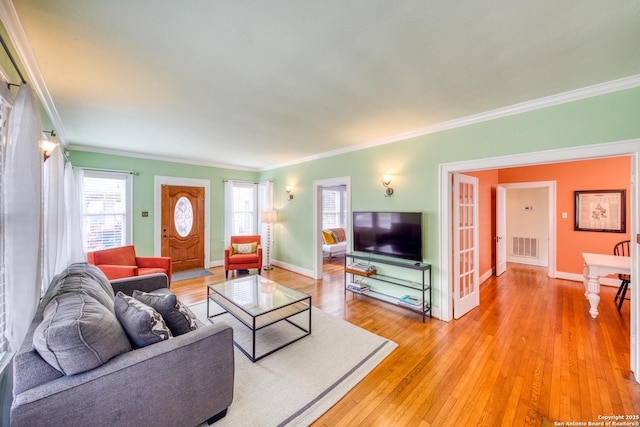 living area with light wood finished floors, plenty of natural light, visible vents, and baseboards