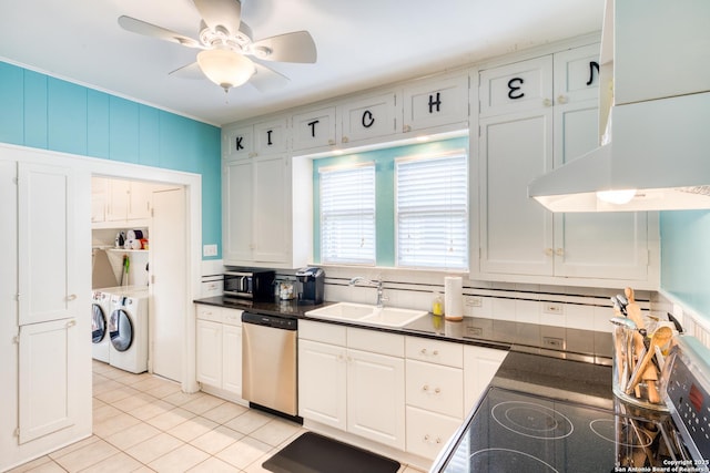 kitchen with appliances with stainless steel finishes, dark countertops, a sink, and separate washer and dryer