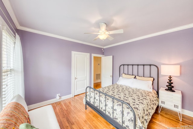 bedroom featuring visible vents, crown molding, baseboards, and wood finished floors