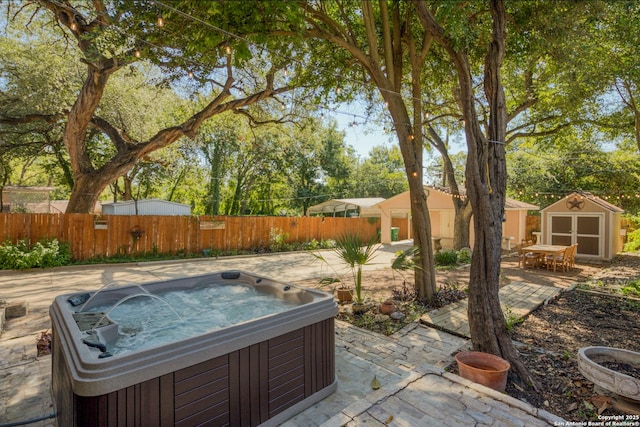 view of patio / terrace featuring a storage unit, an outdoor structure, a hot tub, and fence