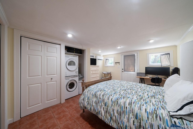 tiled bedroom with recessed lighting, multiple windows, stacked washing maching and dryer, and crown molding