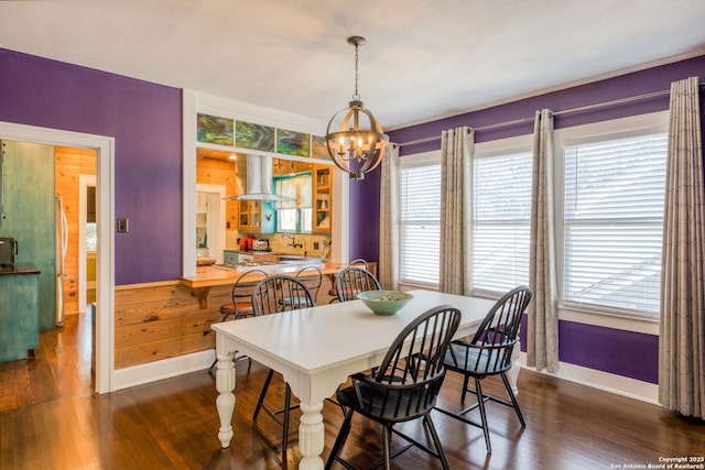 dining area featuring a chandelier, dark wood-type flooring, plenty of natural light, and baseboards