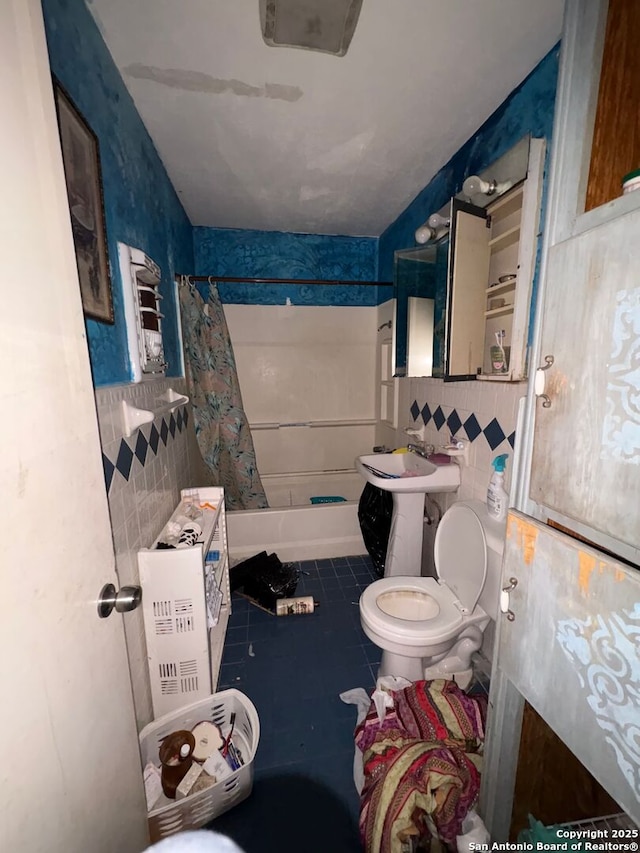 bathroom with shower / bath combination with curtain, tile walls, toilet, and tile patterned floors