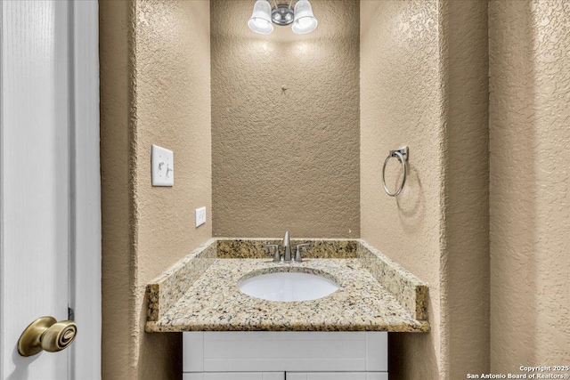 bathroom featuring a textured wall and vanity