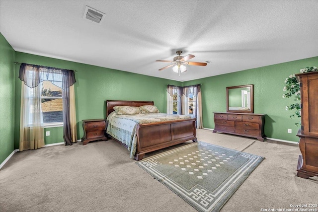 bedroom featuring a textured ceiling, a textured wall, visible vents, baseboards, and carpet