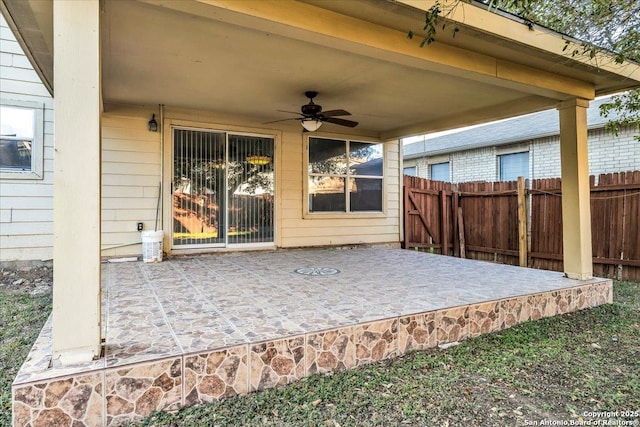 view of patio with fence and a ceiling fan