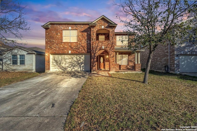 traditional-style house with concrete driveway, brick siding, a yard, and an attached garage