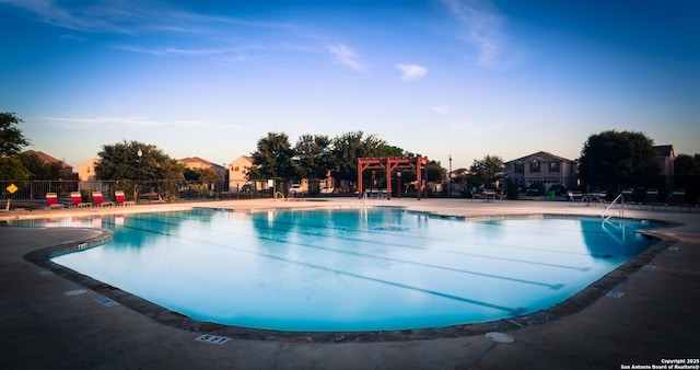 pool with a patio area, fence, and a pergola