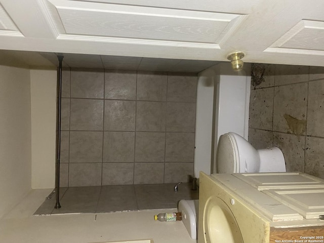 bathroom featuring toilet and washer / dryer