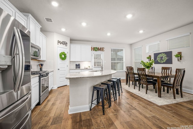 kitchen featuring visible vents, appliances with stainless steel finishes, dark wood-style flooring, and a sink