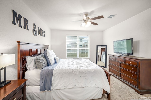 bedroom with carpet, visible vents, and ceiling fan