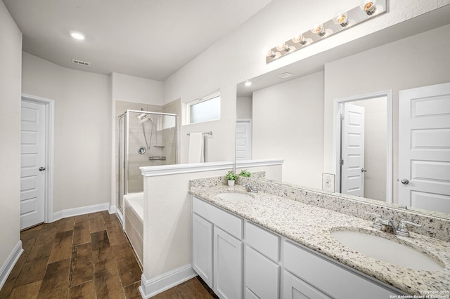 full bathroom with a sink, a shower stall, and wood finished floors