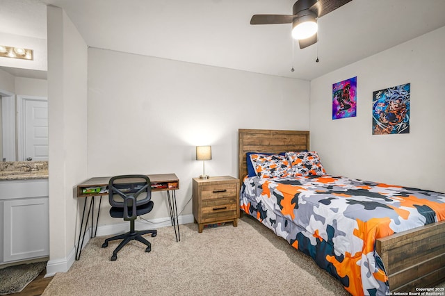 bedroom featuring carpet, baseboards, ceiling fan, and a sink