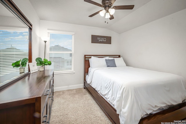 bedroom with lofted ceiling, ceiling fan, baseboards, and light colored carpet