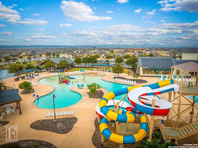 community pool with a water slide, a water play area, and a patio