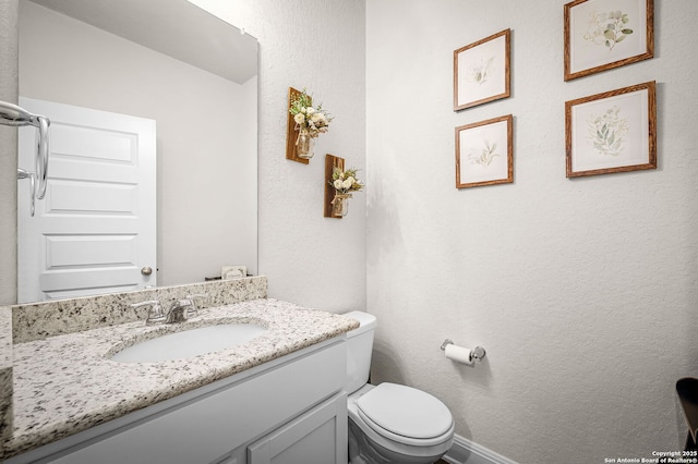 half bathroom with toilet and vanity