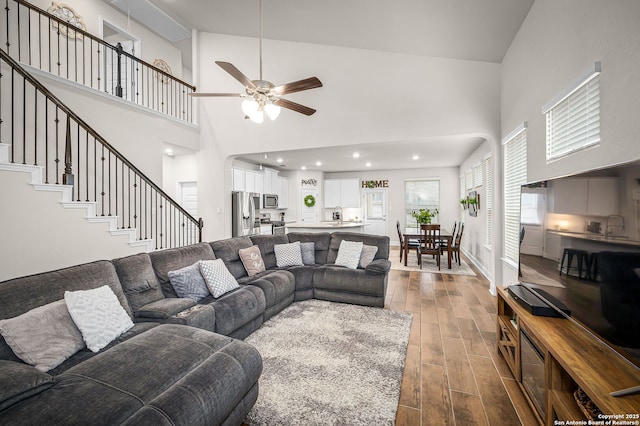 living area with recessed lighting, stairway, dark wood-type flooring, a ceiling fan, and baseboards