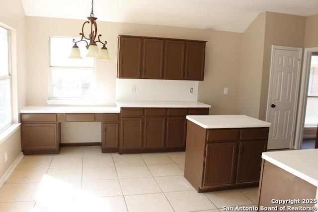 kitchen with light tile patterned floors, light countertops, decorative light fixtures, and an inviting chandelier